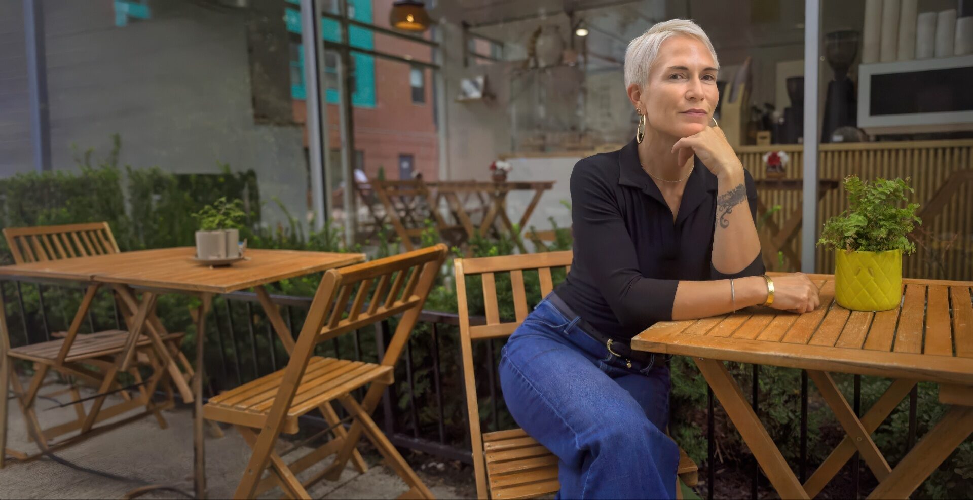 Mari Gardner seated at an outdoor cafe table on a cobblestone street